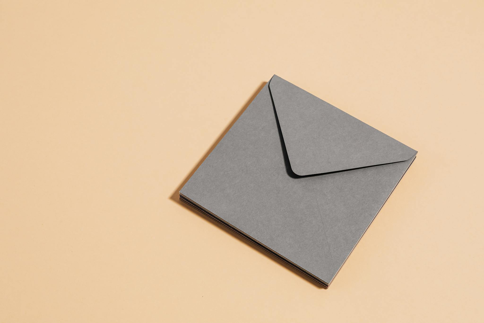 A minimalist gray envelope placed on a beige background showcasing simplicity and elegance.